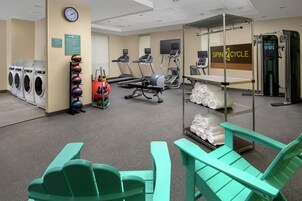 Un gimnasio con equipo de ejercicio, un reloj y un letrero que anuncia SpinCycle.