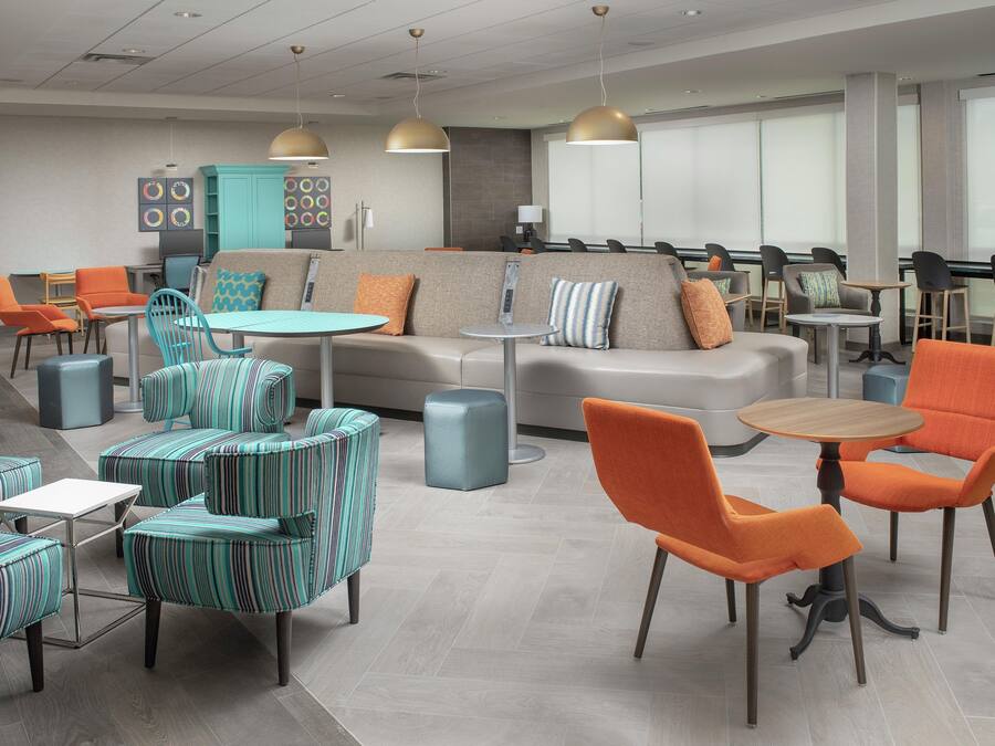 A modern lounge area with seating arrangements, tables, and pendant lighting.