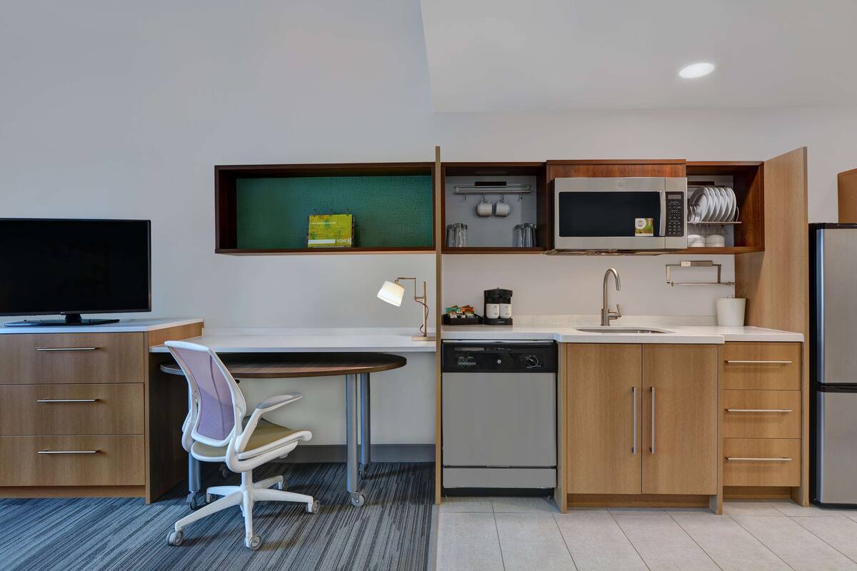 A compact kitchen with a microwave, coffee maker, and dishwasher.