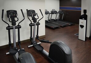 A gym with stationary bikes, treadmills, and an elliptical machine.