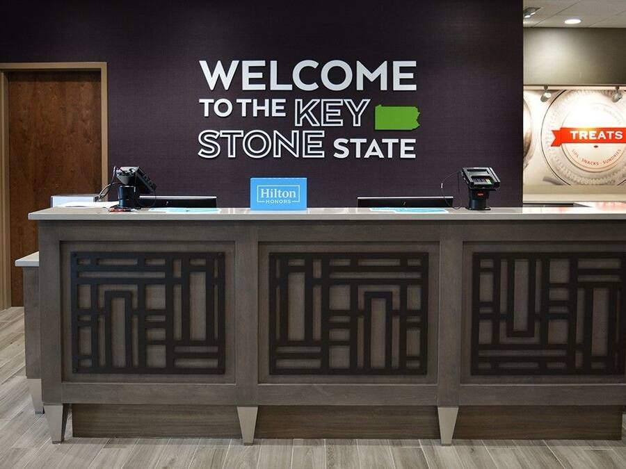 A reception desk with a sign reading "WELCOME TO THE KEY STONE STATE" and a "Hilton Honors" sign.