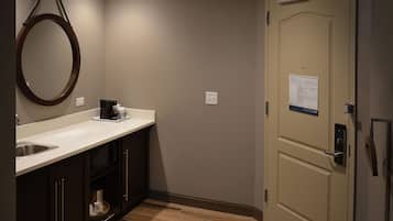 A small, well-lit bathroom with a sink, mirror, and toilet.