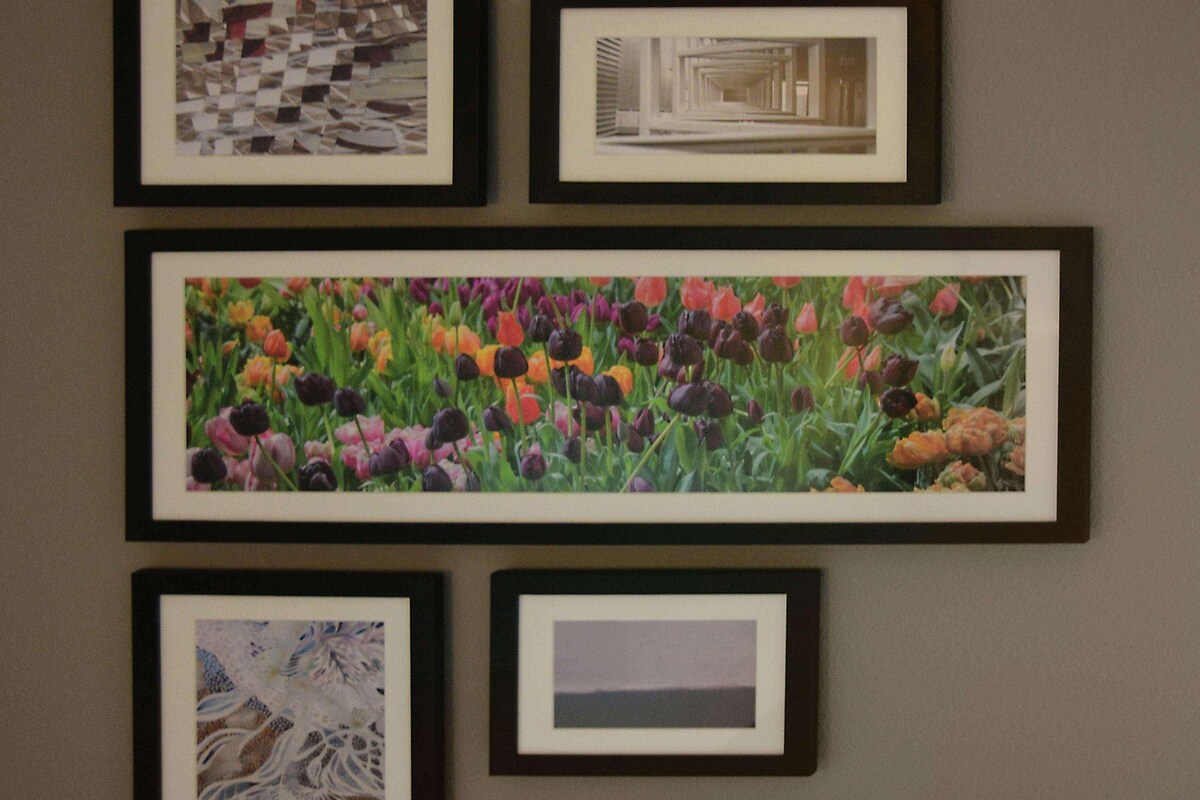 A wall with five framed artworks of various patterns and designs.
