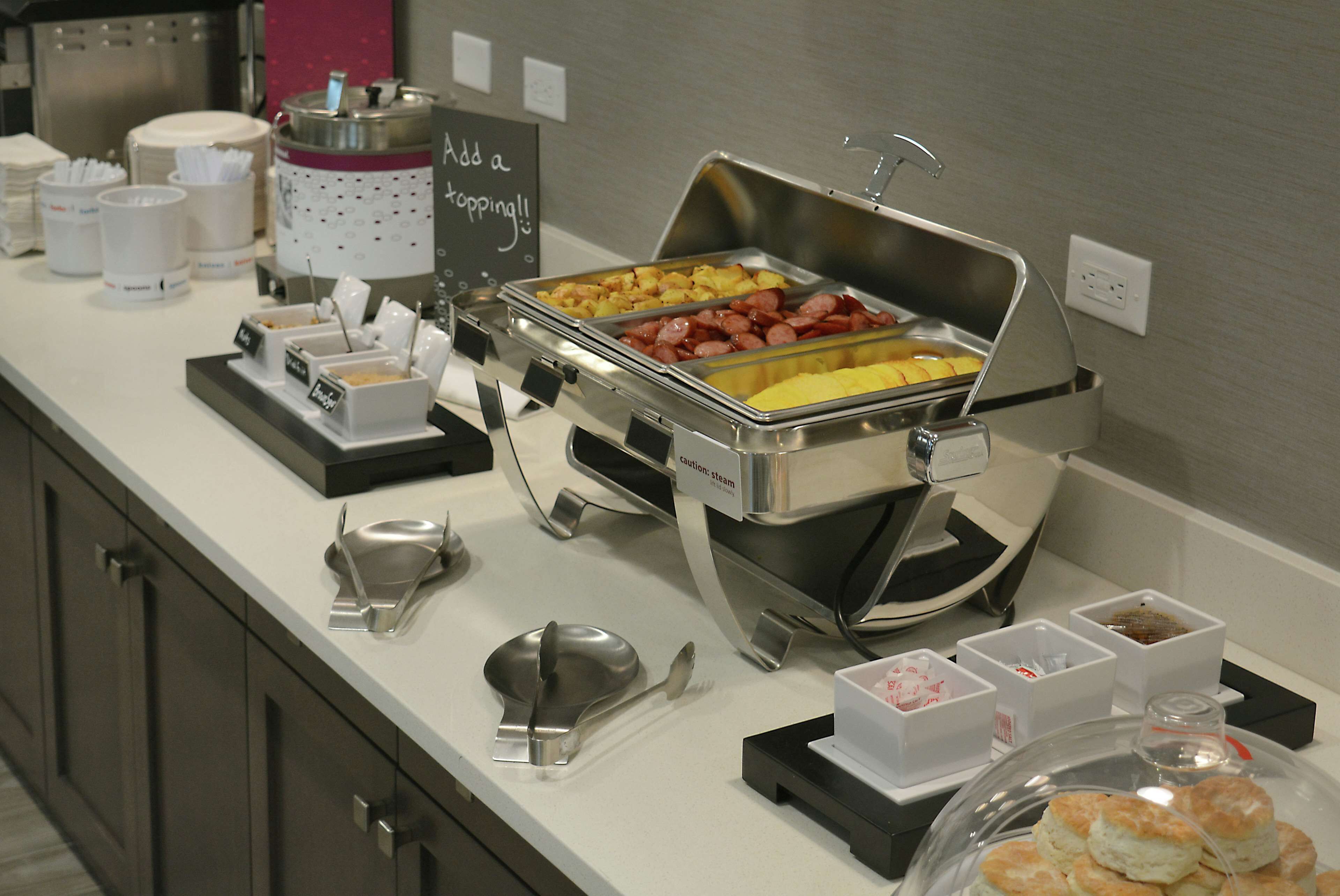 En buffet med forskellige retter og serveringsbestik.