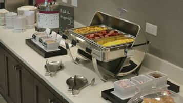 En buffet med forskellige retter og serveringsbestik.