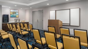 A conference room with rows of chairs, a whiteboard, a coffee station, and a painting on the wall. - Hampton Inn Baltimore Bayview Campus (Baltimore)