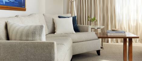 A living room with a sofa, a table, a lamp, and a book on the table.