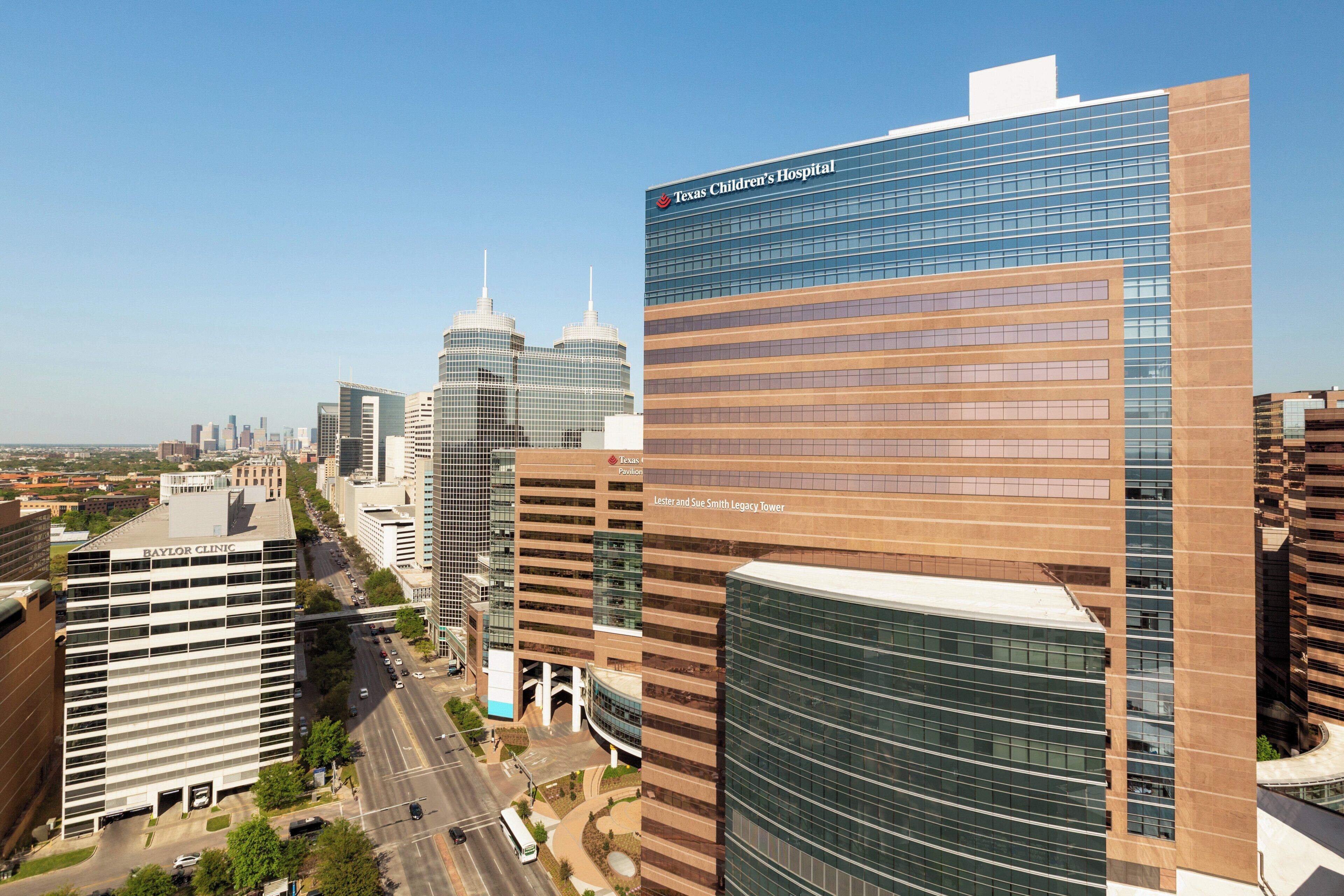 A modern cityscape with prominent buildings including Texas Children's Hospital and Baylor Clinic.