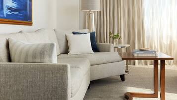A modern living room with a sofa, a side table, a lamp, and a book on the table.