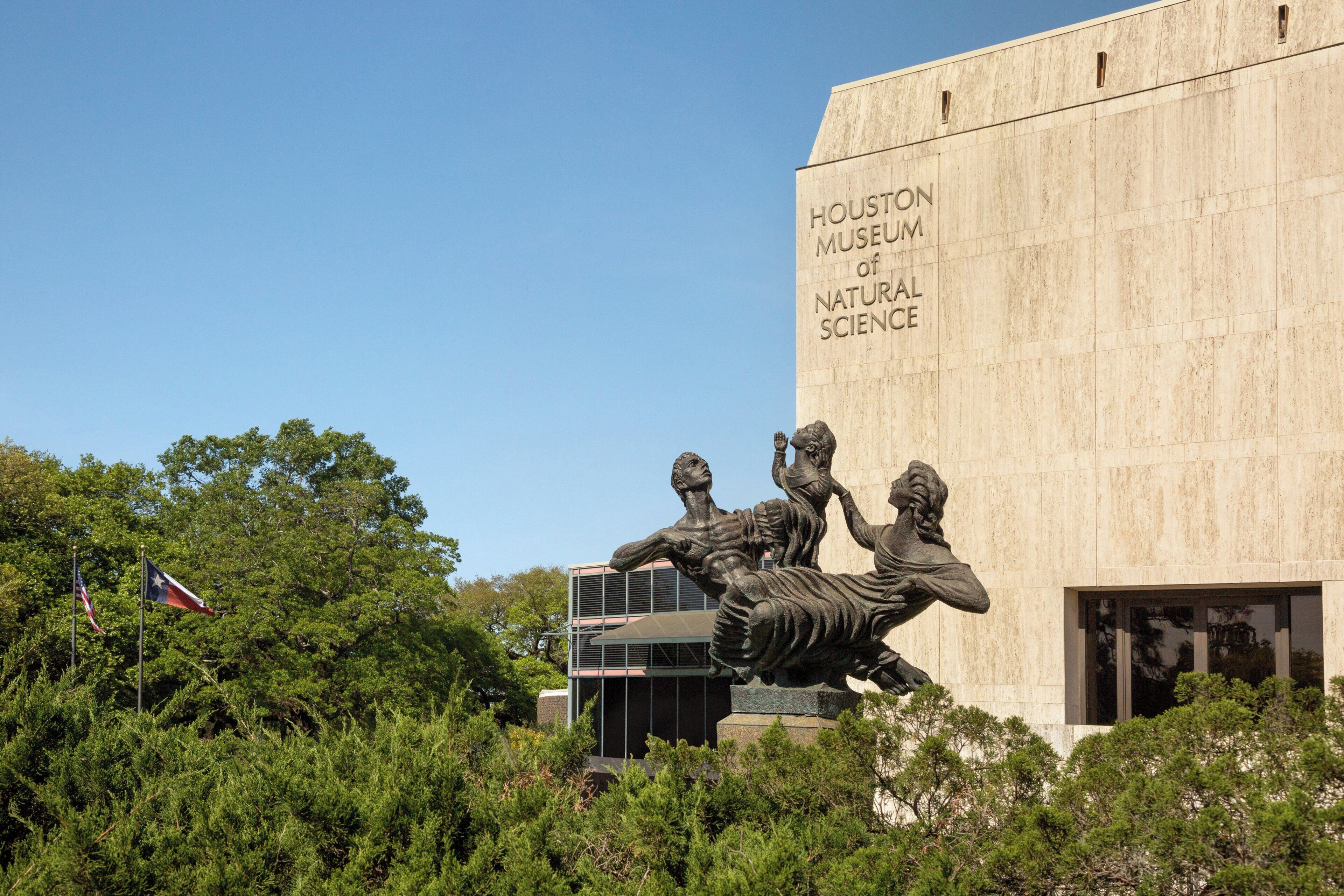 The exterior of the Houston Museum of Natural Science with a large sculpture in front.