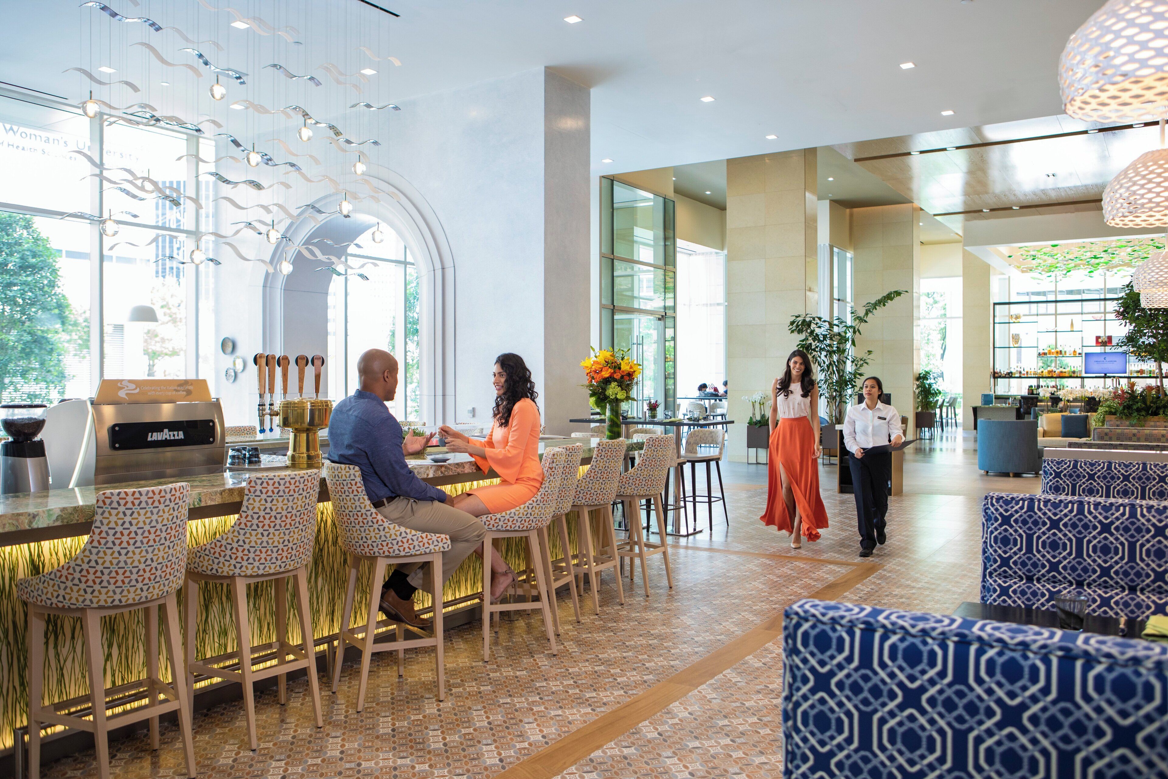 A modern bar area with seating and a coffee machine.