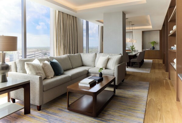 A modern hotel room with a large window, a sofa, a coffee table, and a dining area. - InterContinental Houston by IHG (Houston)