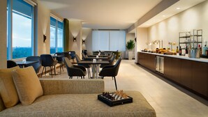 A modern hotel room with a dining area, a sofa, and a chessboard. - InterContinental Houston by IHG (Houston)
