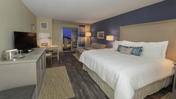 Een hotelkamer met een bed, bureau, televisie en uitzicht.