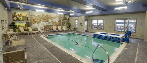 Une piscine avec des chaises longues et une fresque murale.