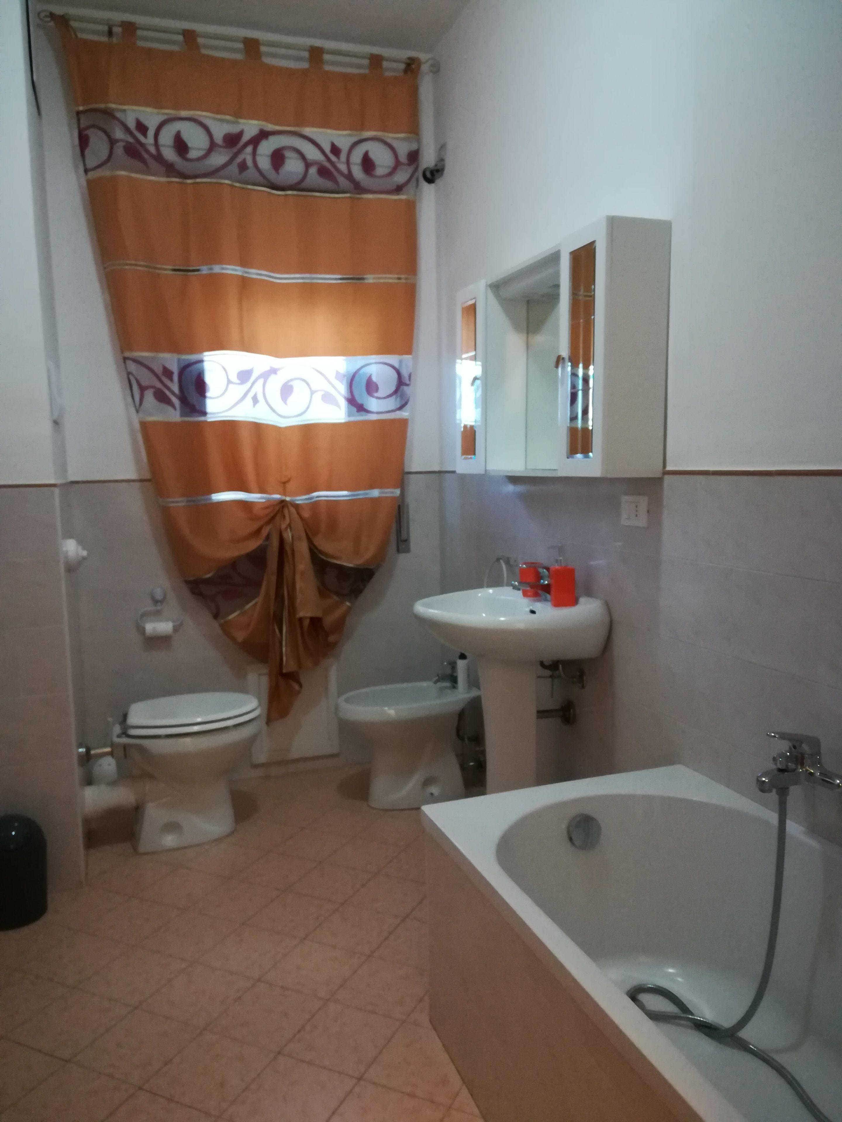 Ein Badezimmer mit Badewanne, zwei Toiletten, einem Waschbecken und einer Dusche.