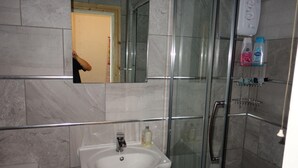 A bathroom with a glass-enclosed shower, a sink, and a mirror. - Swan Inn, Heathrow Airport (Staines)