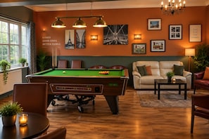 A pool table in a room with a sofa, a lamp, and framed pictures on the wall. - Swan Inn, Heathrow Airport (Staines)