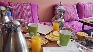 A breakfast setup with a coffee pot, juice glasses, and a plate on a table. - Sun Hostel Marrakech (Marrakech)