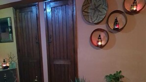 A cozy entrance with a wooden door, a checkered floor, and potted plants. - Sun Hostel Marrakech (Marrakech)