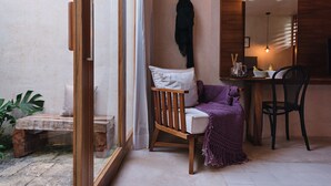 A cozy room with a wooden chair, a small table, and a mirror. - Colonte Hotel Origen (Valladolid)