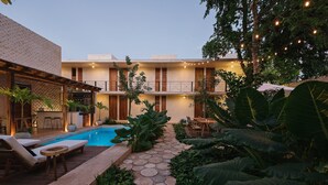 A pool area with lounge chairs and a stone pathway. - Colonte Hotel Origen (Valladolid)