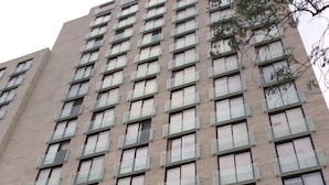 A tall, modern building with a uniform facade, multiple windows, and balconies. - Rukaza El Golf (Santiago)
