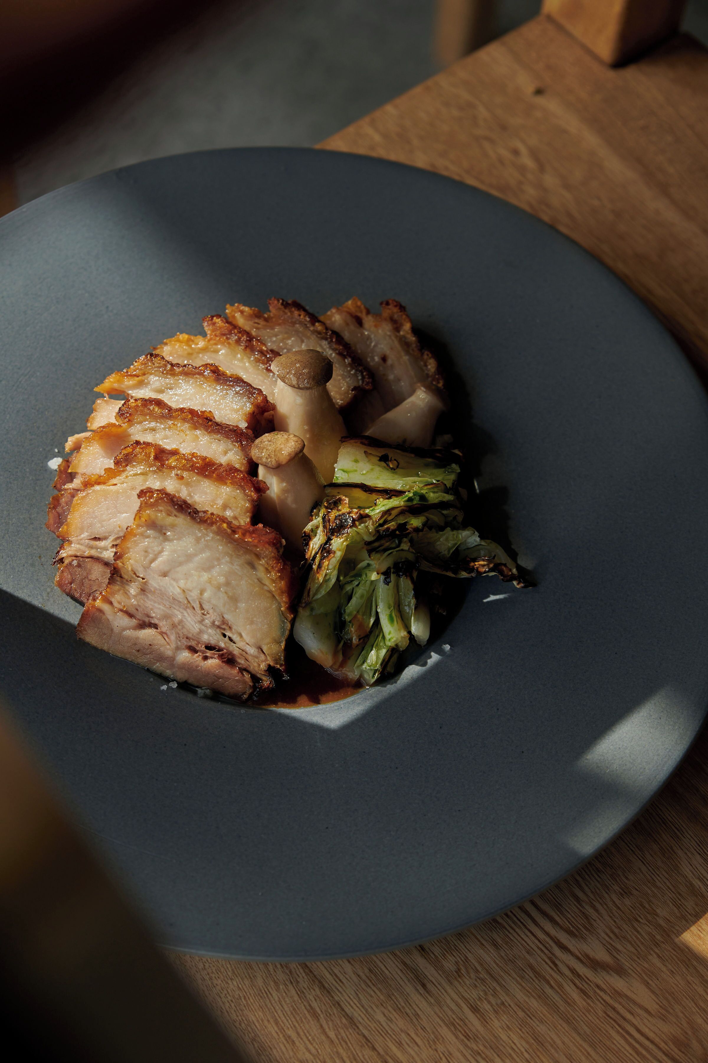 A plate with sliced meat and vegetables.
