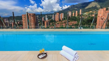 Una piscina al aire libre, sillones reclinables de piscina