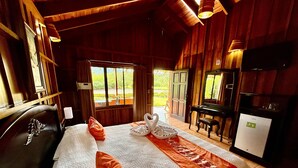 Ein Zimmer mit Holzboden, einem Bett, einem Schreibtisch und einem Fernseher.