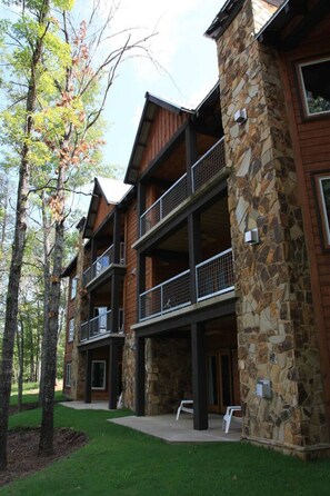 A multi-story lodge with stone and wood exterior, balconies, and a well-maintained lawn. - #701: Trout Hill Condo at Fall Creek Falls (Fall Creek Falls)