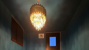 A staircase with a chandelier, a door with a screen, and a blue wall. - Insadong R Guesthouse (Seoul)