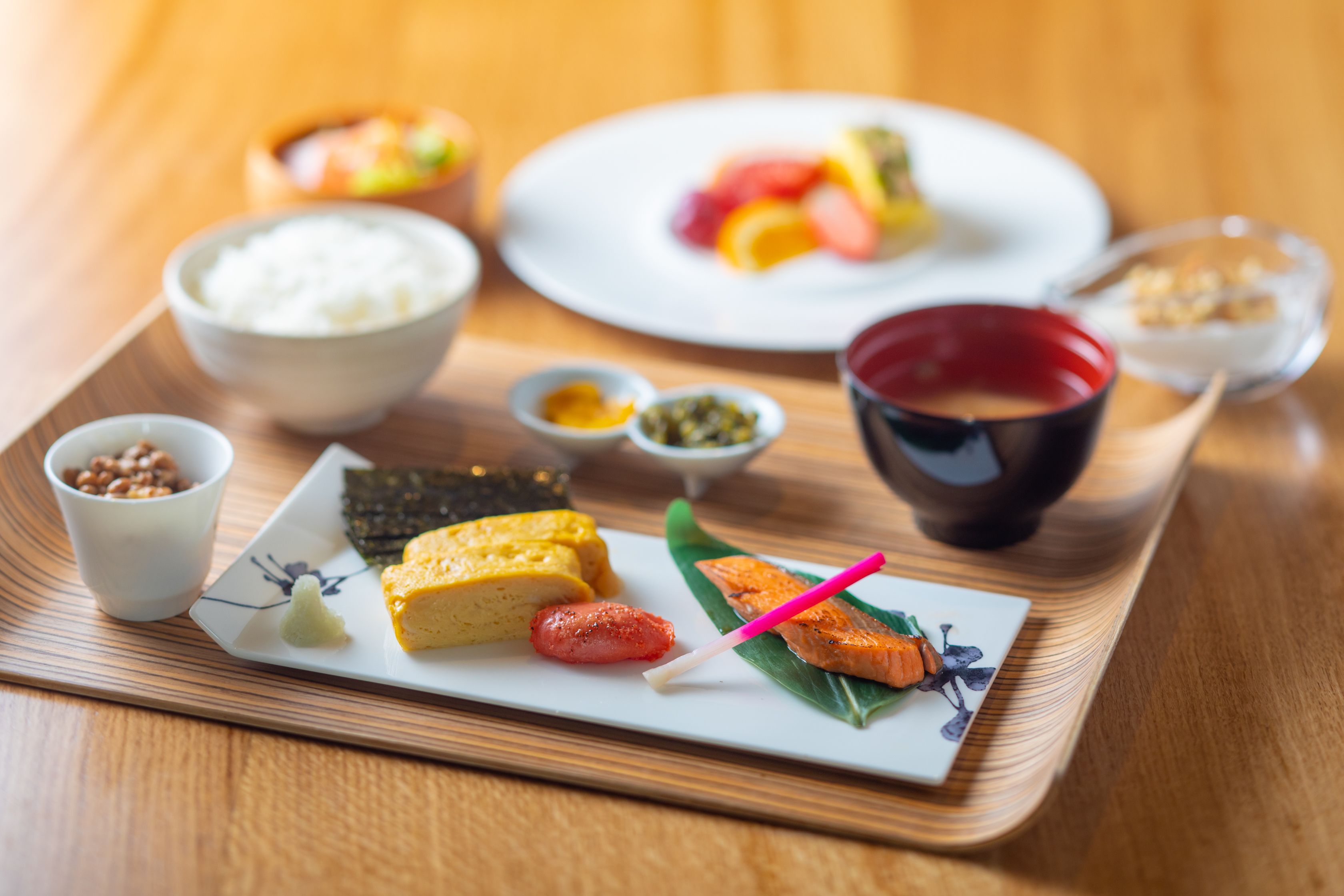 A tray with various Japanese dishes including rice, fish, and vegetables.