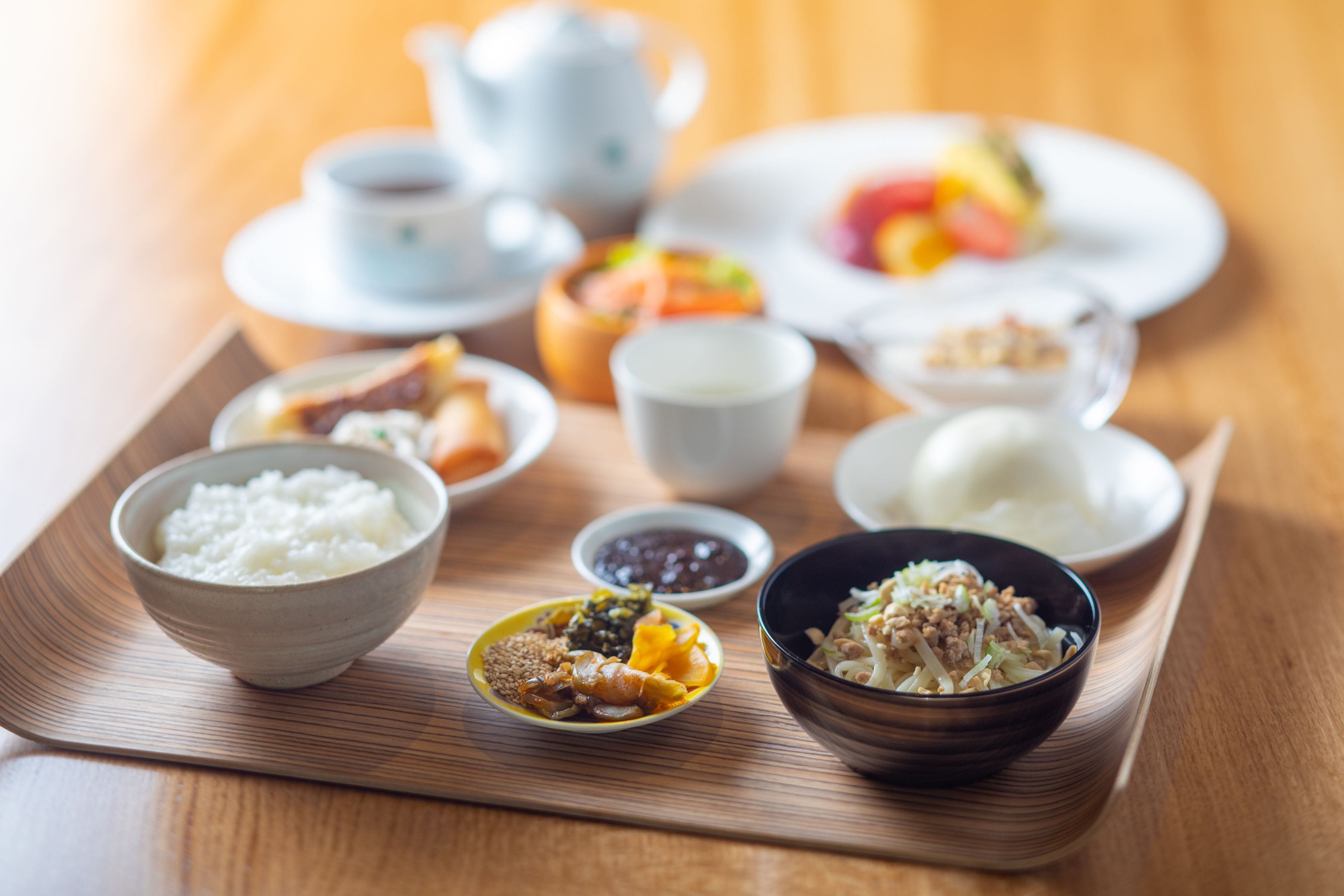 A tray with various bowls of food, including rice, soup, and vegetables.
