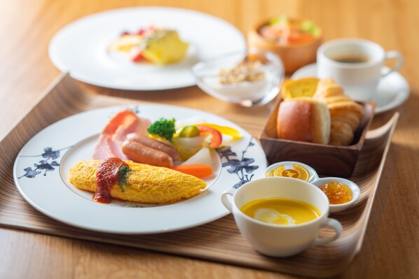 A breakfast tray with an omelette, ham, vegetables, toast, and coffee. - WE Hotel Toya - Dusit Collection (Toyako)