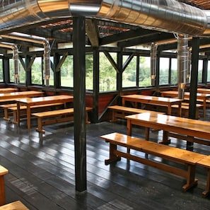An indoor dining area with wooden benches and metal beams.