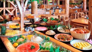 A buffet with various food items and wooden furniture. - Kujukogen Cottage (Taketa)