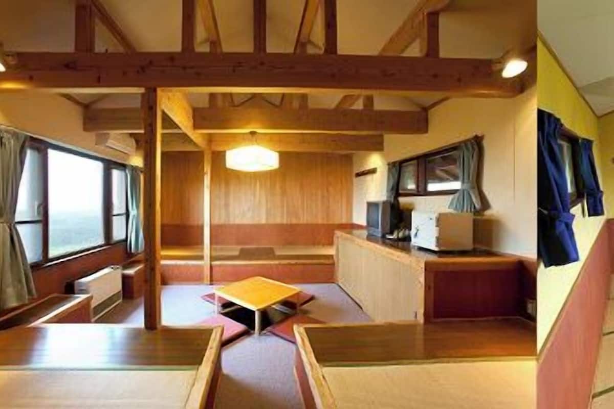 A traditional Japanese-style room with tatami flooring, a low table, and a sliding door.