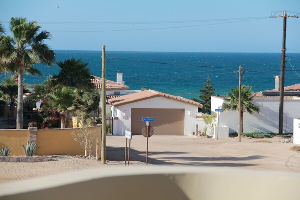 Una proprietà costiera con garage, palme e vista libera sull'oceano.