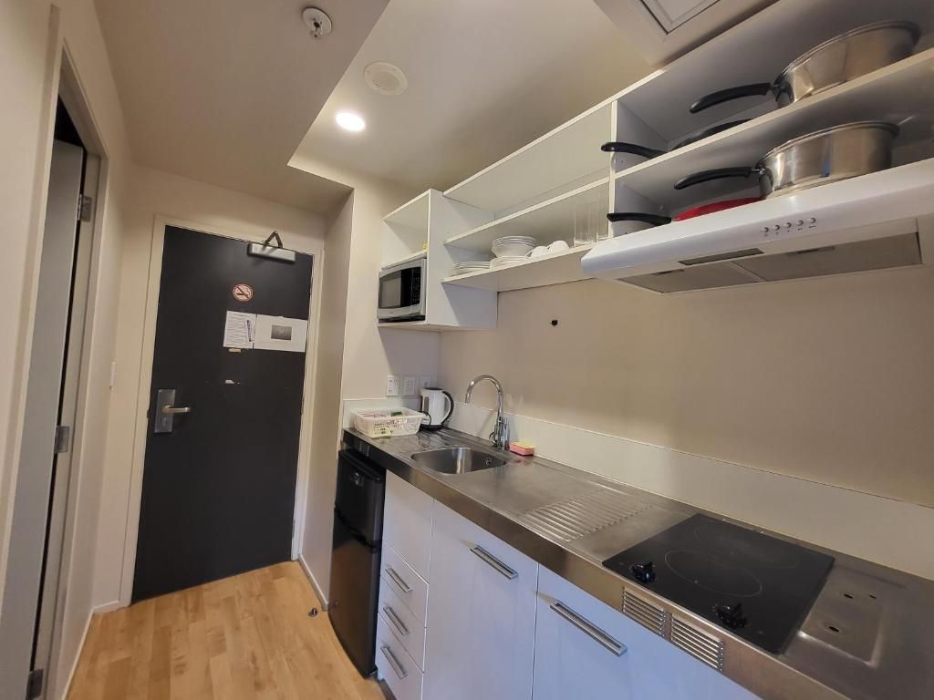 A modern kitchen with a microwave, sink, and stainless steel appliances.