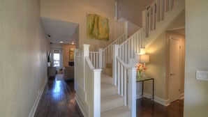 Un intérieur de maison comprenant un escalier en bois, un salon et un coin repas.