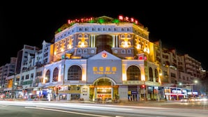 A hotel with a prominent entrance, multiple floors, and illuminated signage. - Louis Hotel Zhongshan (Zhongshan)