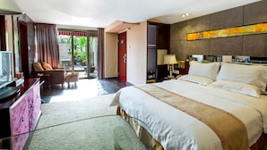A hotel room with a large bed, a desk with a computer, a chair, a TV, and a view of the outdoors. - Louis Hotel Zhongshan (Zhongshan)