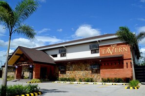 Un edificio con un cartel que dice "The Tavern Hotel & Villas".