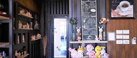 Un acogedor interior de cafetería con un menú, juguetes suaves y una máquina de café.