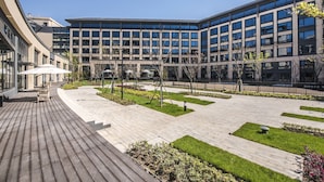A modern building with a courtyard featuring a wooden deck, outdoor seating, and landscaped areas. - Q-Box Hotel Shanghai Sanjiagang (Shanghai)