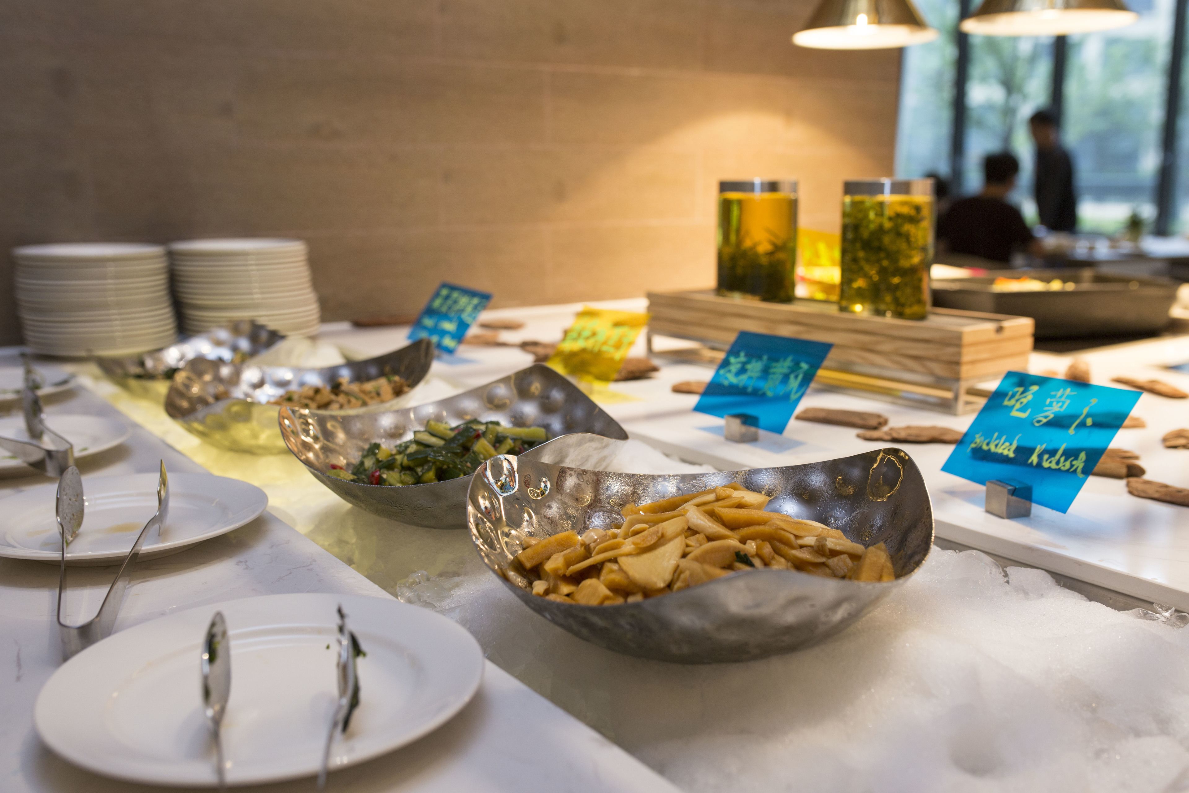 A buffet with various dishes and utensils.