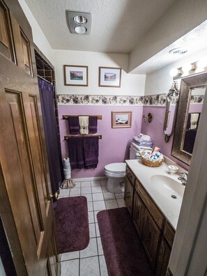 Ein Badezimmer mit Toilette, Waschbecken und zwei gerahmten Bildern an der Wand.