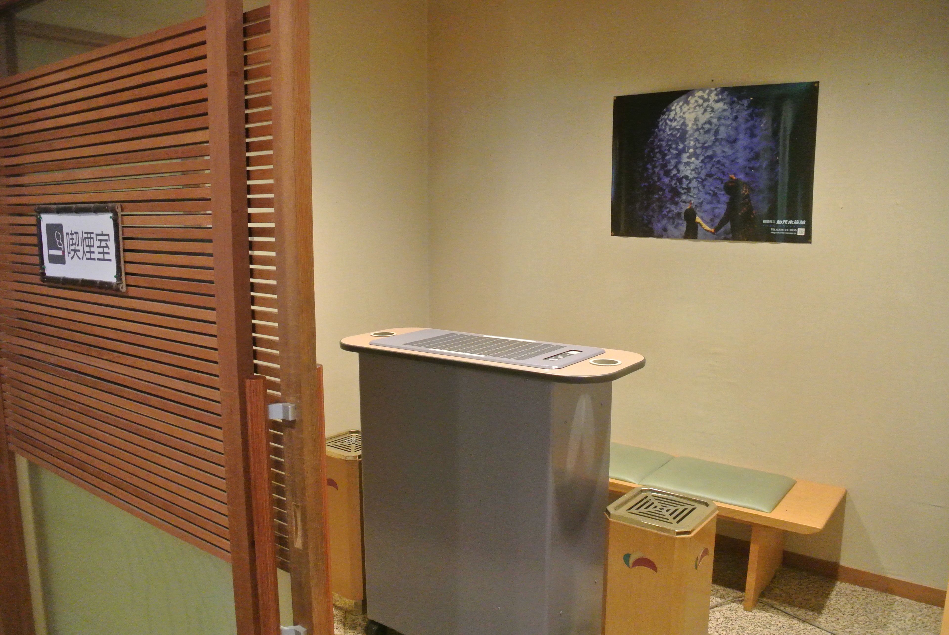 A room with a wooden partition, a small desk with a chair, and a poster on the wall.