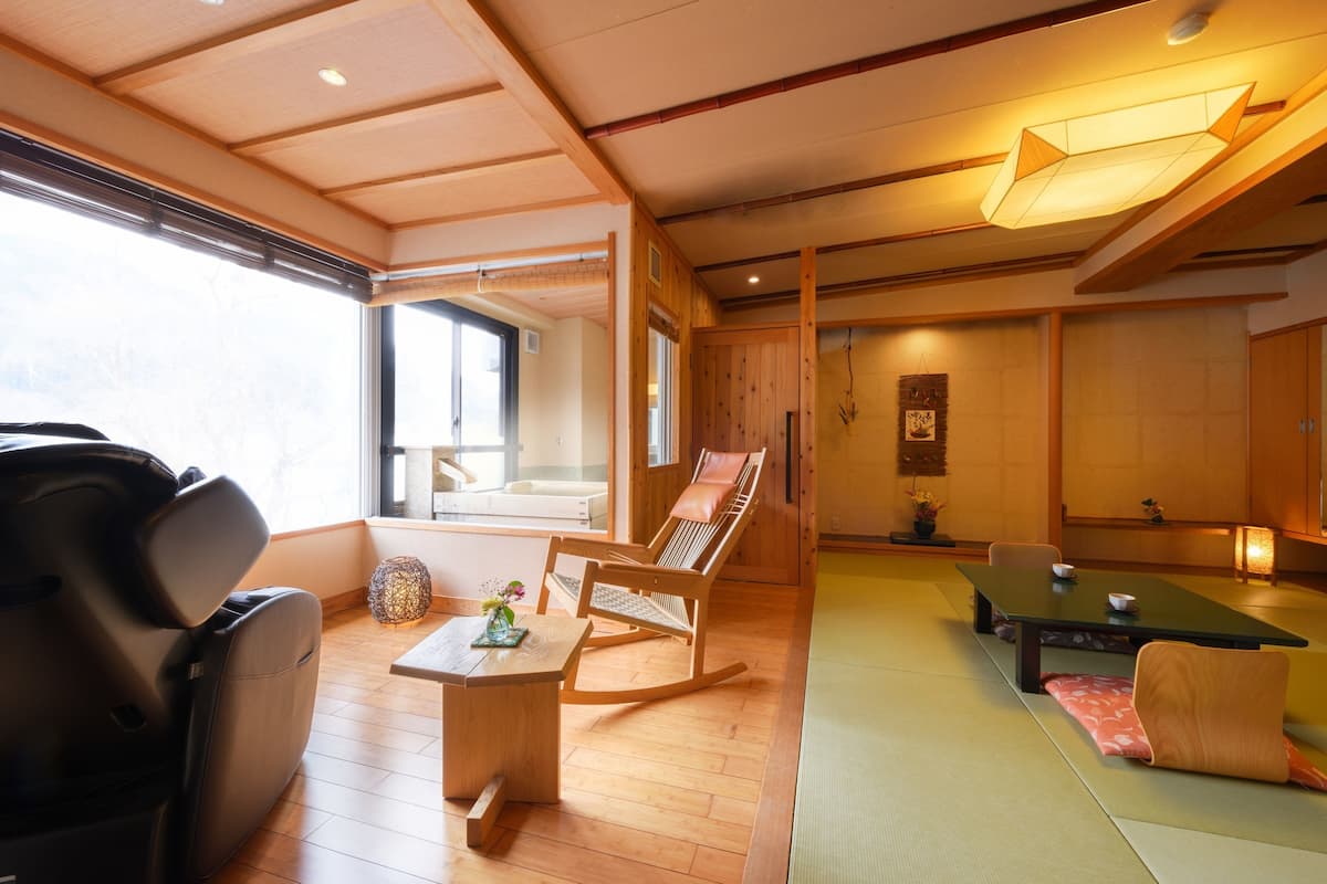 Een traditionele Japanse kamer met tatami vloeren, een lage tafel, een schommelstoel en een bank.